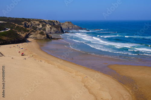 Praia de Odeceixe. Solo Backpacker Trekking on the Rota Vicentina and Fishermen's Trail in Algarve, Portugal. Walking between cliff, ocean, nature and beach.