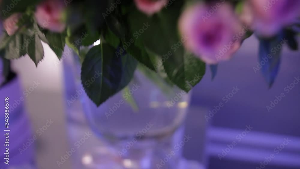 A large bouquet of pale pink roses with green buds, leaves and stems in a glass vase, close-up. A large bouquet of pale pink roses with green buds, leaves and stems in a glass vase, close-up.