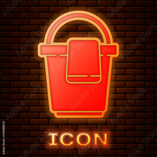 Glowing neon Bucket with rag icon isolated on brick wall background. Cleaning service concept.  Vector Illustration