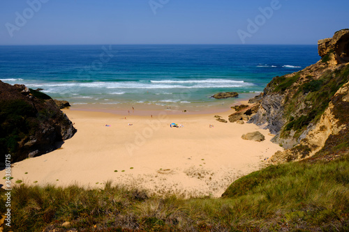 Little beach between the cliff. Solo Backpacker Trekking on the Rota Vicentina and Fishermen's Trail in Alentejo, Portugal. Walking between cliff, ocean, nature and beach. photo