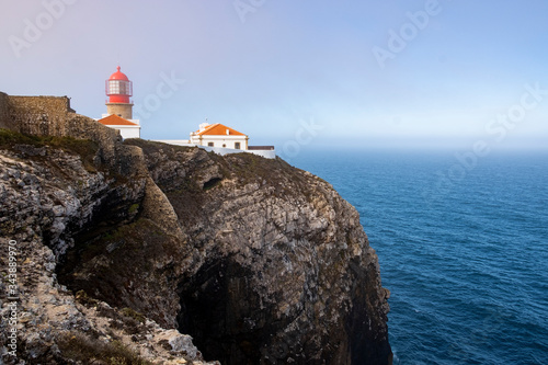 Cliff and lighthouse at Cabo de Sao Vincente. Solo Backpacker Trekking on the Rota Vicentina and Fishermen's Trail in Algarve, Portugal. Walking between  ocean, nature and beach. photo