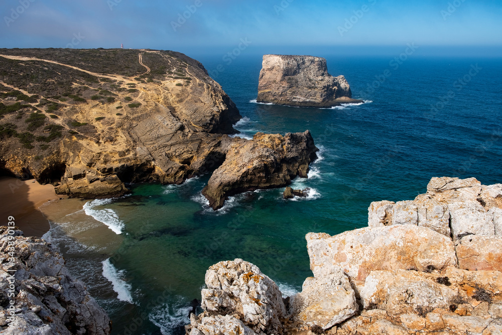 Obraz premium Cliff at Cabo de Sao Vincente. Solo Backpacker Trekking on the Rota Vicentina and Fishermen's Trail in Algarve, Portugal. Walking between ocean, nature and beach.