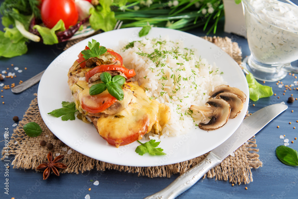 Fired cordon bleu chicken served with rice and parsley on plate.Chicken fillet baked in cheese with rice and vegetables. Fired cordon bleu chicken served with rice and parsley on plate.Chicken fillet baked in cheese with rice and vegetables.