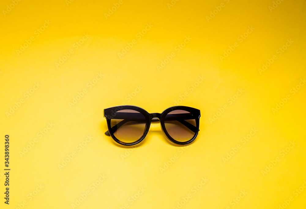 Black glasses on a yellow background with an open seat. Black semi-transparent glasses. Black glasses on a yellow background with an open seat. Black semi-transparent glasses.