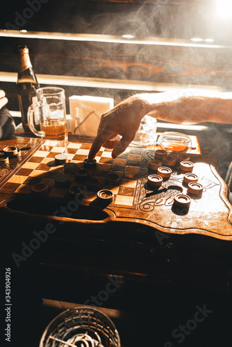 Close up of man playing checkers in a cafe, a hairy man hand, touching checkers