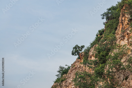 Rock mountain cliff and tree on the top isolated on white background. Beautiful Rock mountain in Khao Ngu Stone Park, Ratchaburi ,Thailand.