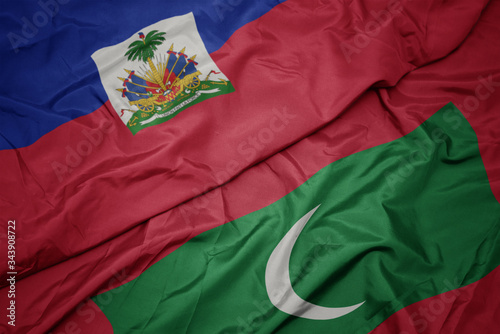 waving colorful flag of maldives and national flag of haiti.