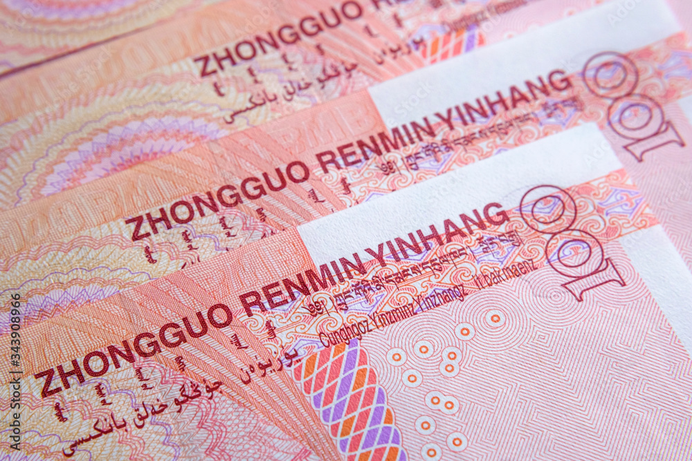 Fototapeta premium Part of Chinese yuan renminbi banknotes photographed with selective focus. Concept for economy of China. Words in different languges translate as 