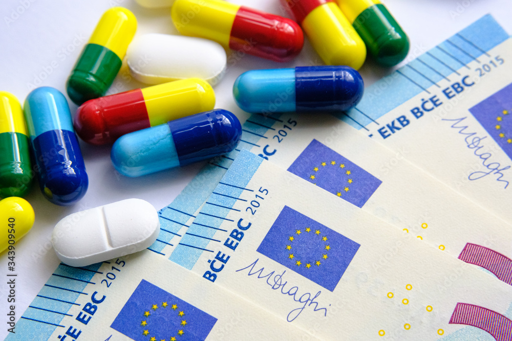 Pile of of different colouful pills placed next to 20 euro banknotes. Illustrative for cost of medical bills, health insurance and other subjects. Macro. Pile of of different colouful pills placed next to 20 euro banknotes. Illustrative for cost of medical bills, health insurance and other subjects. Macro.