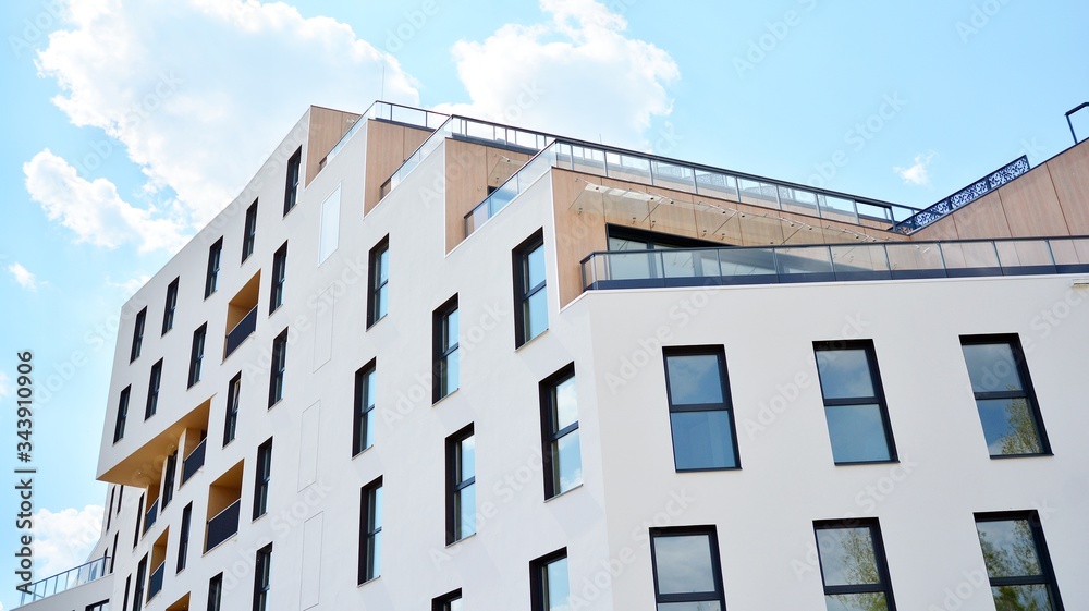 Contemporary residential building exterior in the daylight. Modern apartment buildings on a sunny day with a blue sky. Facade of a modern apartment building