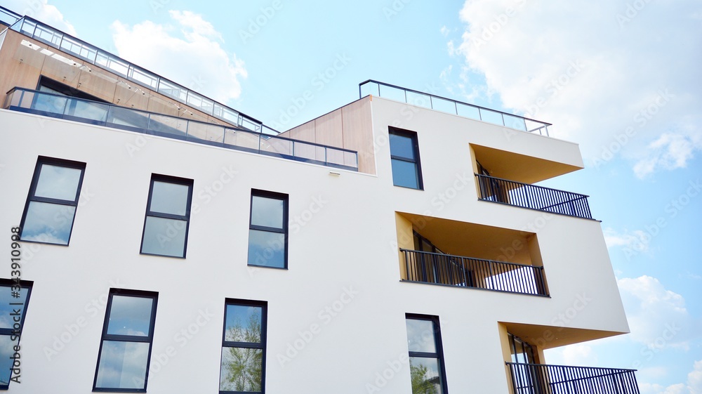 Contemporary residential building exterior in the daylight. Modern apartment buildings on a sunny day with a blue sky. Facade of a modern apartment building