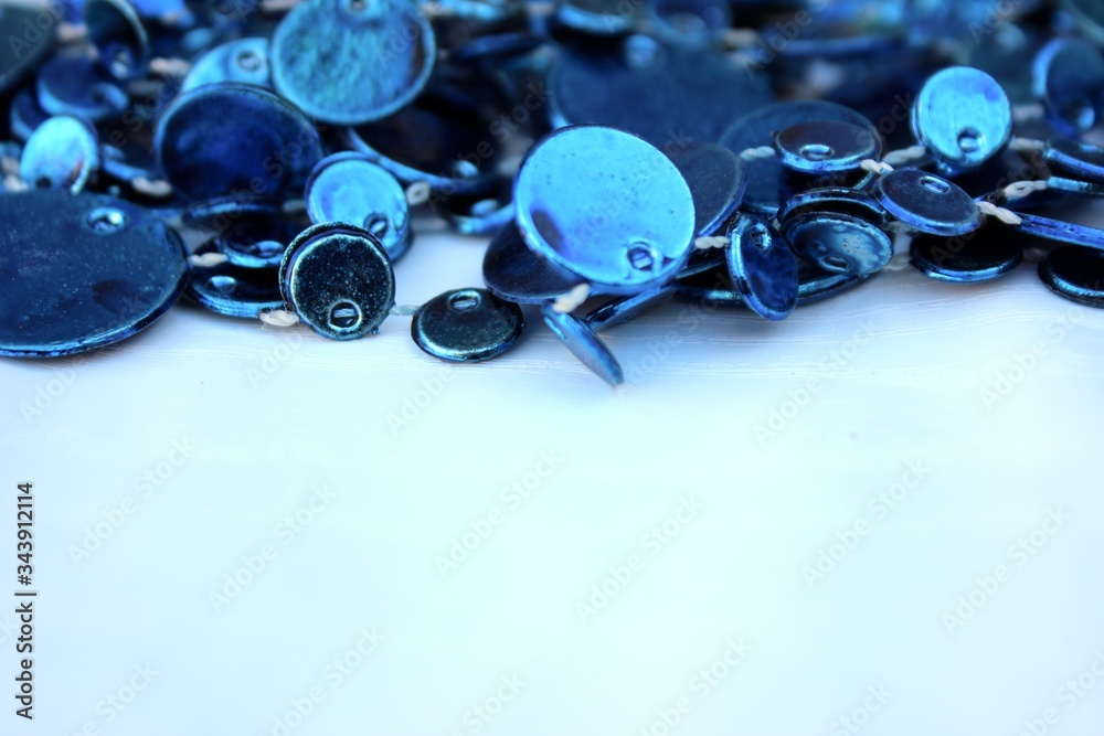 Blue shiny decoration on a white background. Christmas blue beads isolated on white with place for text. Close-up new year background with Christmas balls toned trendy classic blue color. holiday