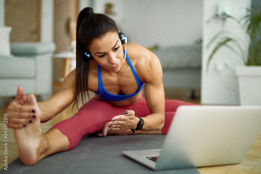 Obraz premium Young athletic woman making a vlog about stretching exercises at home.