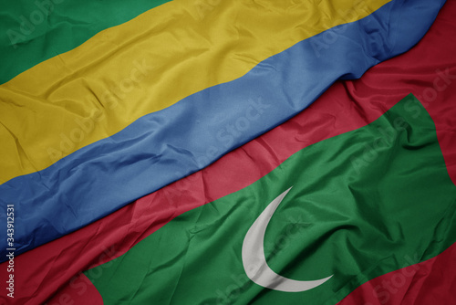 waving colorful flag of maldives and national flag of gabon.