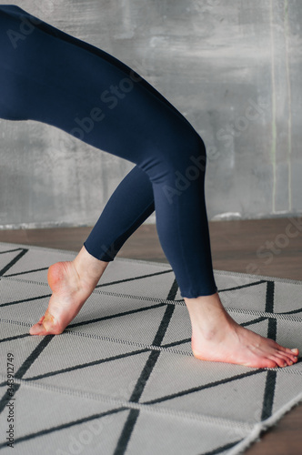 Young sporty woman practicing yoga lesson sitting in Sukhasana exercise, Easy Seat pose with mudra gesture, working out, female arms with wrist bracelets close up, studio