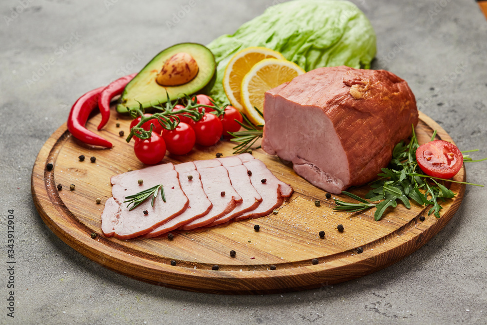 Sliced ham with spices, lettuce, avocado and tomatoes on wooden cutting board. Сold meat plate. Fresh prosciutto Sliced ham with spices, lettuce, avocado and tomatoes on wooden cutting board. Сold meat plate. Fresh prosciutto
