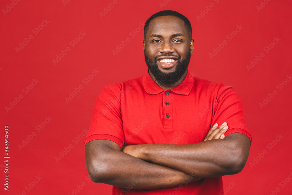 Portrait of a cheerful young african american black man standing isolated over red background.