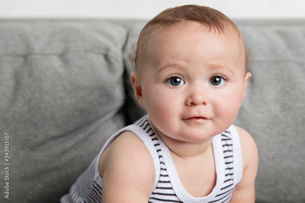 Close-up portrait of cute baby boy sitting on sofa at home Close-up portrait of cute baby boy sitting on sofa at home
