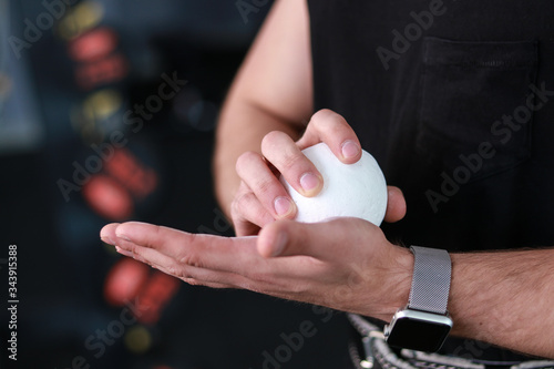 young man rubs magnesia in a ball before training