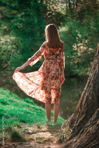 Slender Beautiful Active Free Girl on a summer background in a light dress