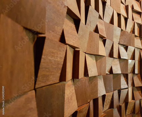 Fototapeta Naklejka Na Ścianę i Meble -  Widok ściany złożonej z małych asymetrycznych drewnianych kostek.