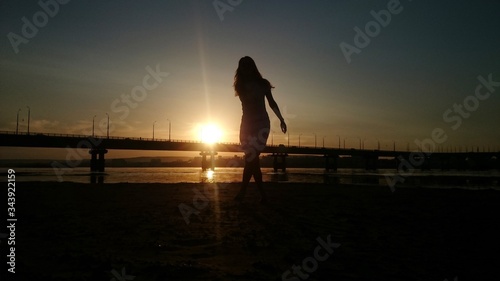 Girl on the sunset of the bridge