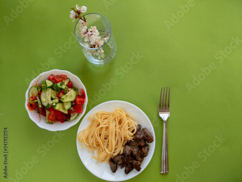 spaghetti with chicken hearts and salad