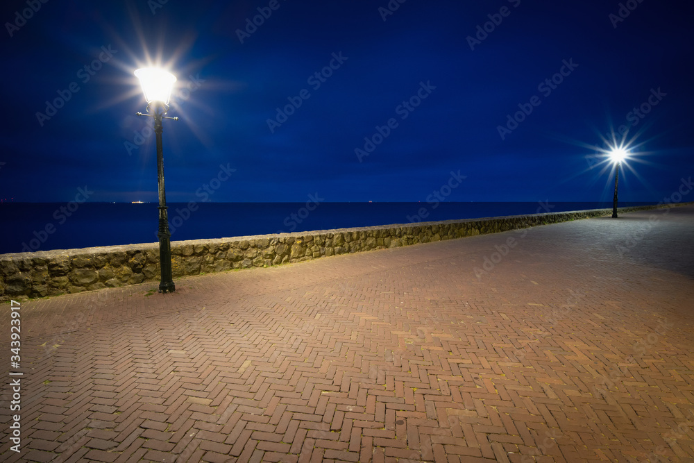 View from the boulevard with illuminated street lamp during the blue hour, Urk Netherlands