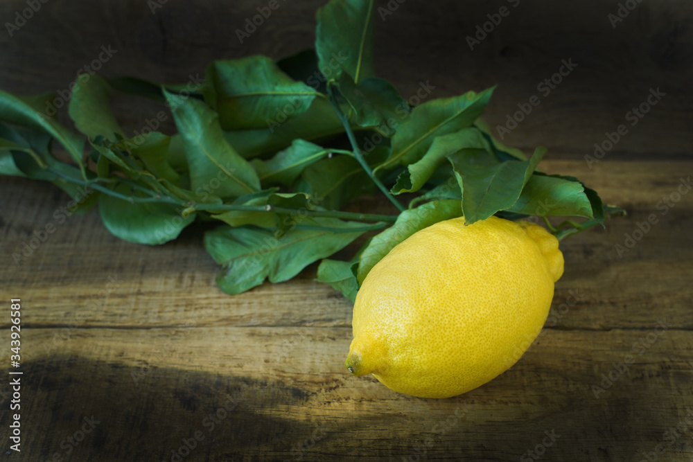 Fresh lemon with leaves on a wooden background