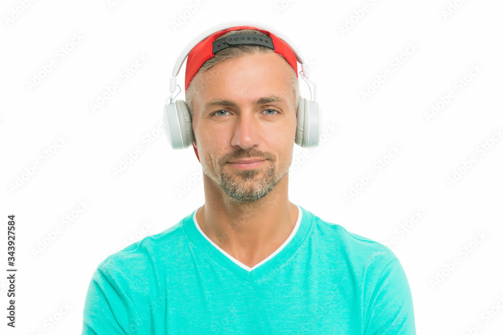 Fototapeta premium Guy in cap listen music stereo headphones. Good mood. Modern wireless headphones. Perfect sound concept. Electronic dance music and house tracks. Instrumental music. Man headphones white background