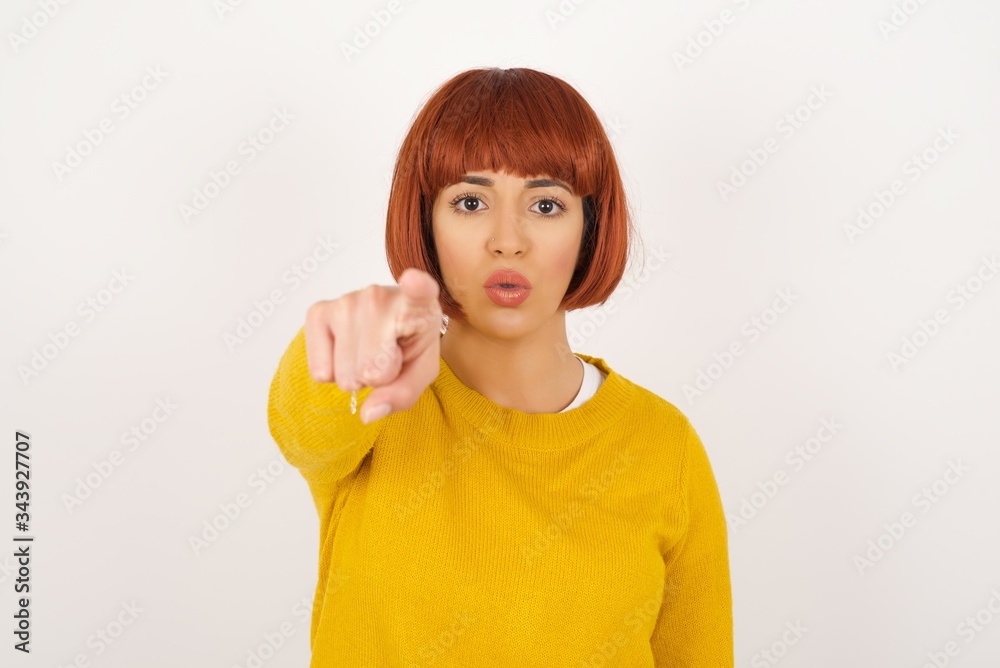 Indoor shot of cheerful young woman in casual clothes indicates happily at you, chooses to compete, has positive expression. beautiful clever student makes choice, isolated on gray Wall Indoor shot of cheerful young woman in casual clothes indicates happily at you, chooses to compete, has positive expression. beautiful clever student makes choice, isolated on gray Wall