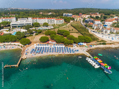 Aerial view of blue umbrellas at Medulin beach during the summer, Croatia. photo