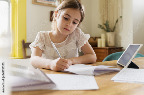 Girl (6-7)†working on schoolwork at home photo