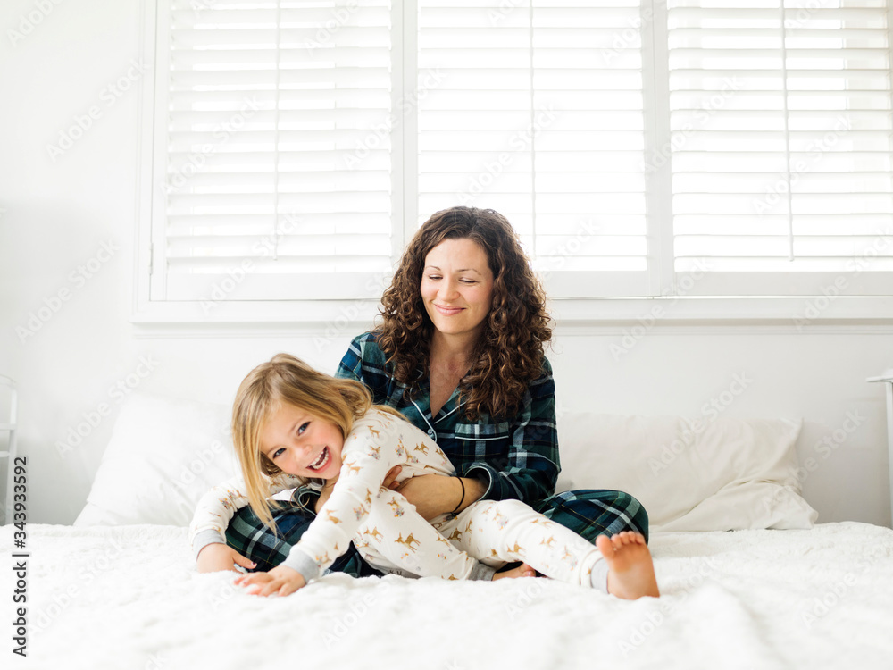 Mother and daughter hugging on bed Mother and daughter hugging on bed