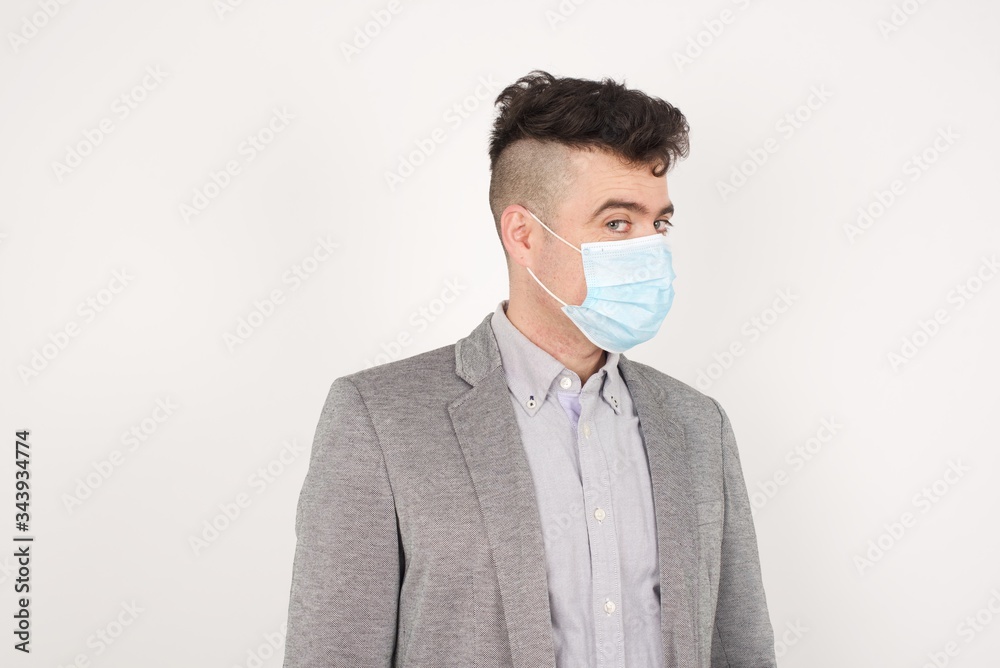 Shy blond boy smiling looking to the camera. Caucasian charming young man sanding against studio background feeling shy. Shy blond boy smiling looking to the camera. Caucasian charming young man sanding against studio background feeling shy.