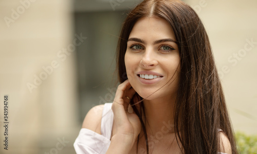 Portrait Of Young Beautiful Woman. Beautiful young brunette fashion model posing outdoor. Summer outdoor portrait. Focus on woman  blurred background.