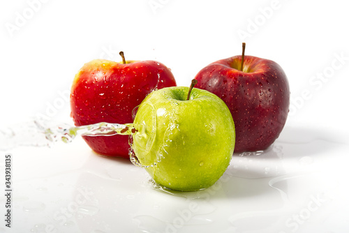 three apples with water splash. Three apples red, green, and yellow with warer splashes on white background photo