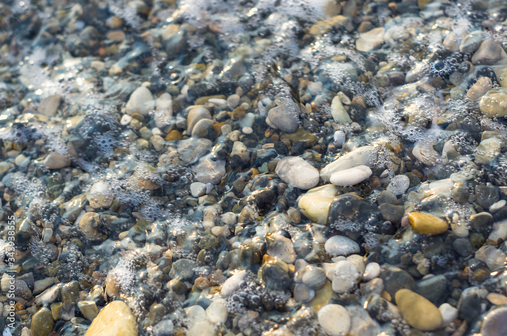 pebble stones on the sea beach, the rolling waves of the sea with foam pebble stones on the sea beach, the rolling waves of the sea with foam
