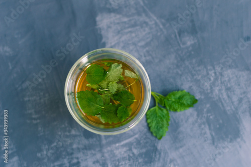 Tea with mint leaves on a beautiful gray-blue background. Screensaver for relaxation. Place for an inscription, copyspace