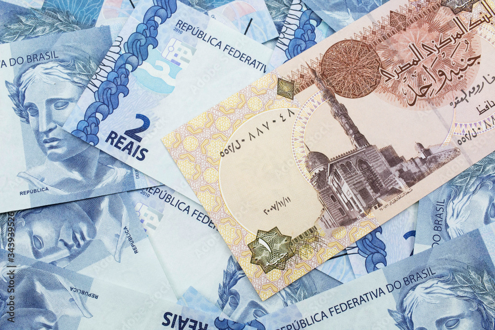 Fototapeta premium A close up image of an Egyptian one pound bank note with Brazilian two reais bank notes in macro