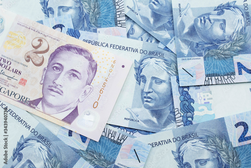 Fototapeta premium A close up image of a two dollar bill from Singapore close up in macro with Brazilian two reais bank notes