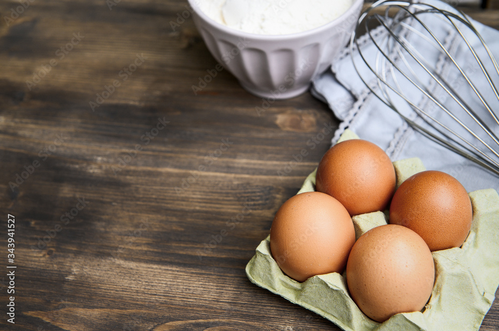 Baking cooking ingredients: flour, eggs and kitchen textile. Wooden background. Baking cooking ingredients: flour, eggs and kitchen textile. Wooden background.