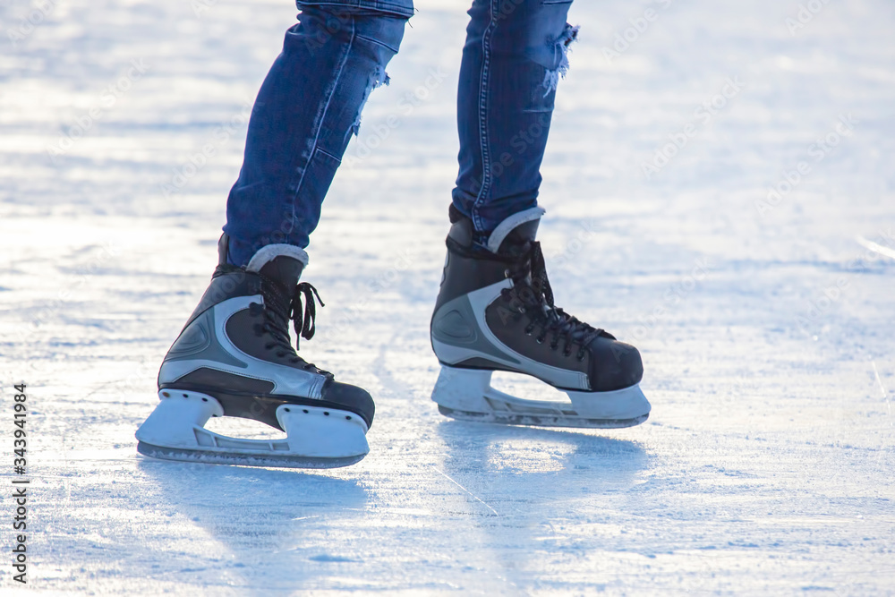 Legs of a man skating on an ice rink. Hobbies and sports. Vacations and winter activities. Legs of a man skating on an ice rink. Hobbies and sports. Vacations and winter activities.