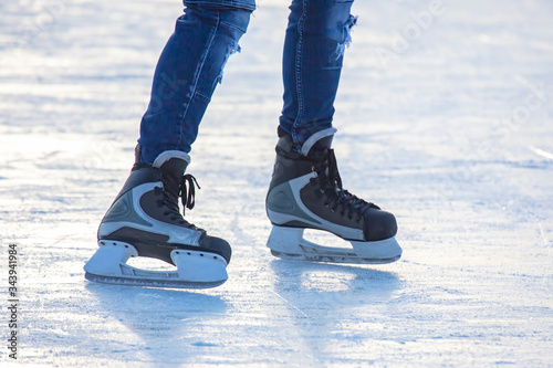 Legs of a man skating on an ice rink. Hobbies and sports. Vacations and winter activities.