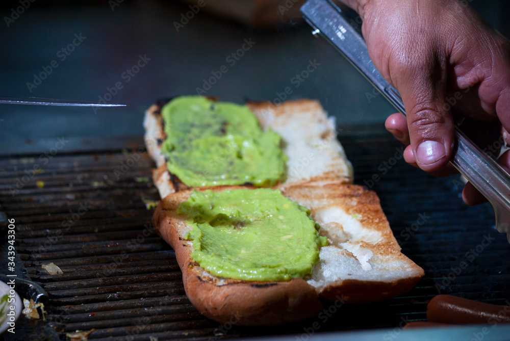 Hands of man preparing roasted bread wings fathoms on the street called Shuco in Guatemala, version of the Hot Dog Hands of man preparing roasted bread wings fathoms on the street called Shuco in Guatemala, version of the Hot Dog