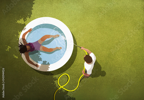 Man filling wading pool with water for wife