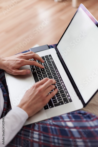 A person typing on laptop with pajamas