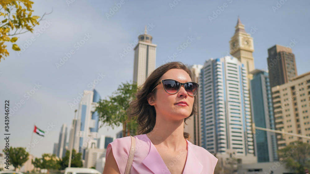 A beautiful young woman is walking in the center of Dubai.