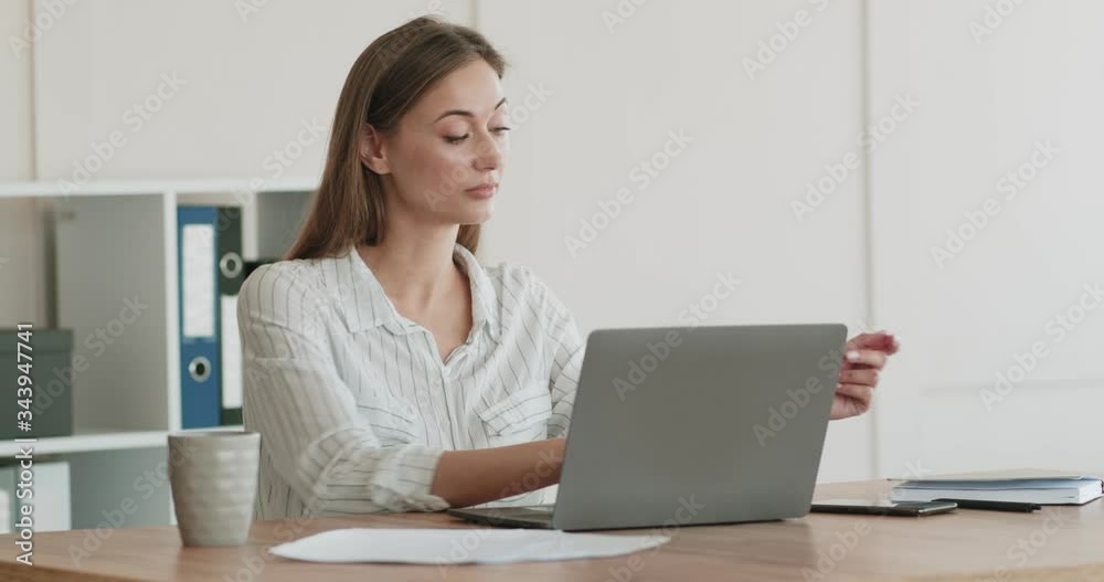 Friendly business woman talking on phone, working on laptop Friendly business woman talking on phone, working on laptop