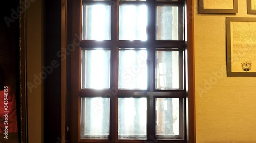 VIew inside of historical museum, glass window with wooden partitions and ancient documents hanging on the wall in frames. Stock footage. Reconstruction of historical events and places at the museum. photo